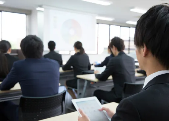 机の上に置かれた「丸栄産業（株）」の社名入り黄色い安全ヘルメット。