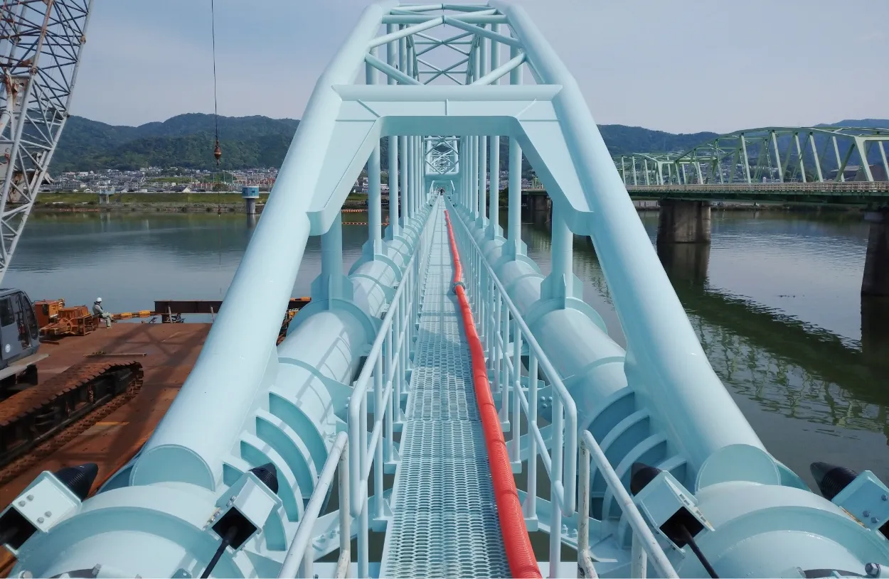 河川に架かる水色の水管橋