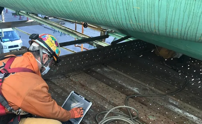 画面を見ながら、現場で測定をしている